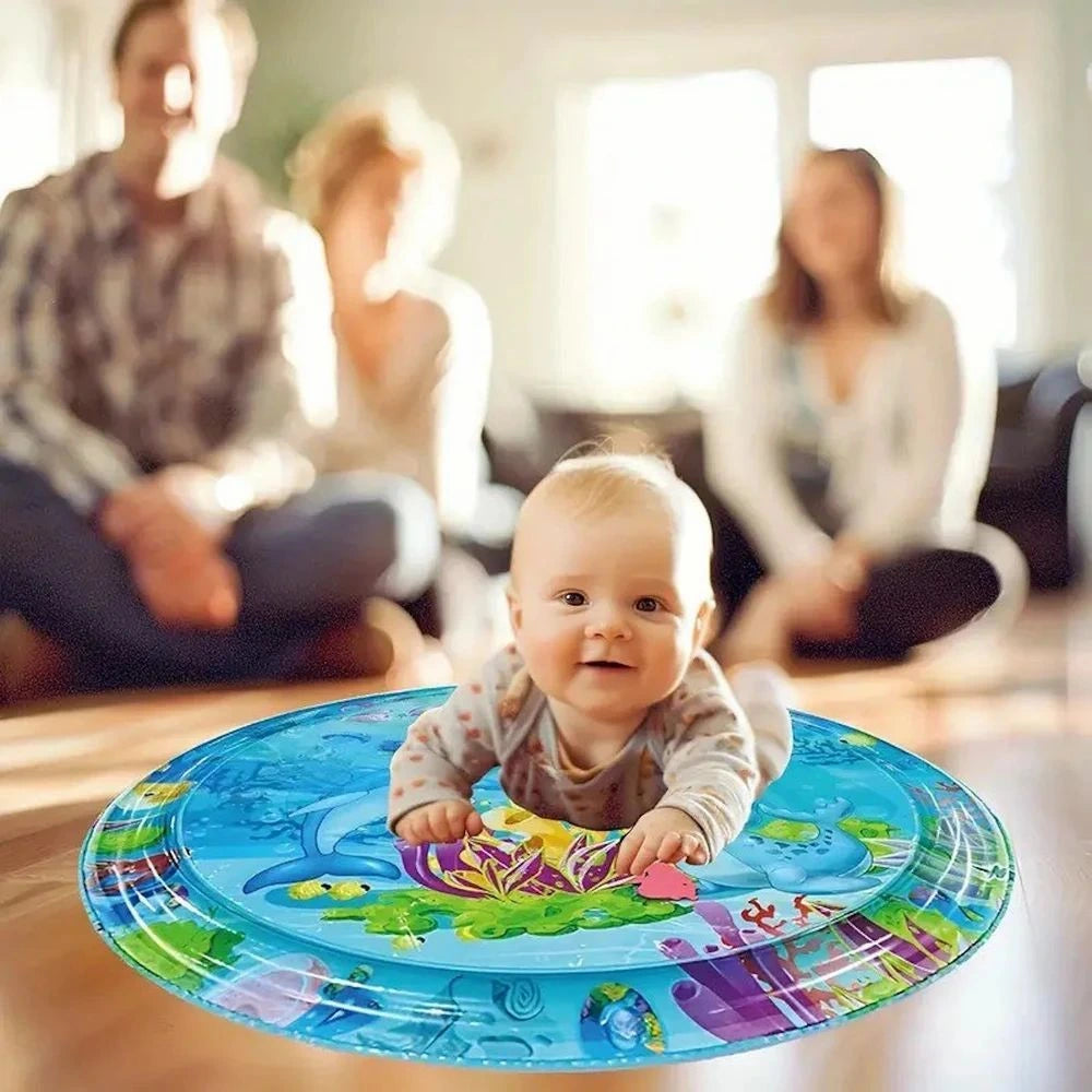 Baby playing with a colorful water play mat in a home setting.