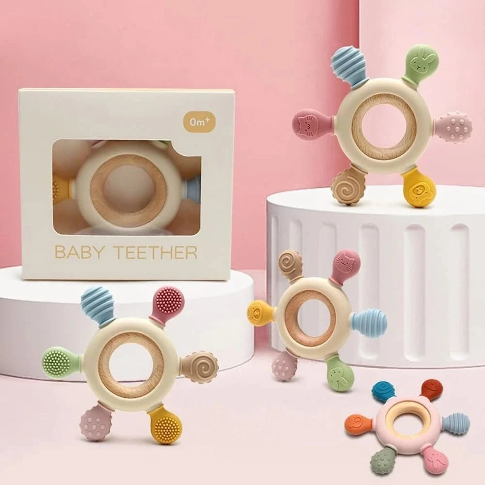 Colorful baby teether with packaging on a pink background