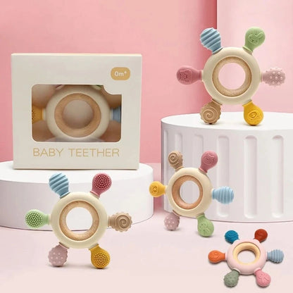 Colorful baby teether with packaging on a pink background